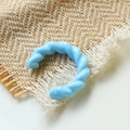 Dettaglio di un anello a C ritorto azzurro in acrilico con texture in resina opaca - Blu