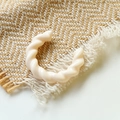 Dettaglio dell'orecchino a C in acrilico crema intrecciato su tessuto in stile vintage - Crema