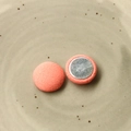 Dettaglio macro di bottoni magnetici rivestiti in tessuto rosa corallo su piatto beige - Arancione Chiaro