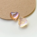 Dettaglio di ciondoli in resina a forma di cuore cangianti con finitura glitterata - Arancione