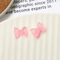Macro di due fiocchi in resina rosa traslucida per decorazioni unghie e fai da te creativo - Rosa