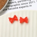 Dettaglio di fiocchi in resina rossa su un piatto bianco per nail art e decorazioni fai-da-te - Rosso