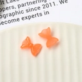 Macro di due fiocchi in resina arancione luminosi per nail art e decorazioni fai da te - Arancione