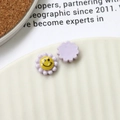 Vista macro di ciondoli margherita in resina lavanda con smiley per creazioni DIY - Viola