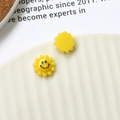 Dettaglio macro di ciondoli in resina a girasole con sorriso e retro liscio per DIY - Giallo