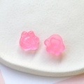 Vue macro de breloques en résine pailletée rose en forme de patte de chat pour loisirs créatifs - Rose rouge