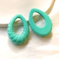 Dettaglio macro di ciondoli in resina a spirale verde menta per creazione di gioielli - Verde