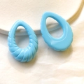 Dettaglio di ciondoli in acrilico azzurro a forma di goccia con trama a spirale - Blu