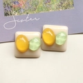 Detalle de pendientes cuadrados de resina con gemas en color amarillo y verde - Un Parche