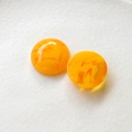 Dettaglio macro di due cabochon in resina arancione marmorizzata per orecchini e gioielli fai da te - Giallo