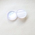 Dettaglio di cabochon in resina occhio di gatto aurora con riflessi perlati iridescenti - Bianco