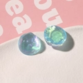 Vista macro de dijes de resina azul iridiscente con purpurina estrellada y efecto onda - Azul