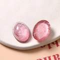 Makroaufnahme von rosa ovalen Harz-Cabochons mit Silberfolien-Textur für DIY-Schmuck - Rosa