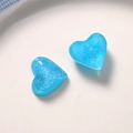 Close-up of sky blue resin heart charm with silver glitter for DIY jewelry making - Blue