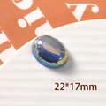 Vista macro de dije ovalado facetado de resina azul 22x17mm en plato blanco - Estilo Ovalado Grande / 1 Pieza / Azul Fantasía