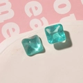 Detail of square mint blue resin charms with glitter particles on marble tray - Lake Green