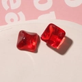 Vista macro de piezas de joyería de resina cuadrada roja con purpurina dorada en bandeja - Rojo