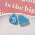 Macro shot of blue irregular triangle resin charms with water ripple texture for DIY crafts - Blue
