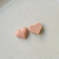 Detalle macro de dijes de resina de corazón melocotón en bandeja para joyería DIY - Rosa