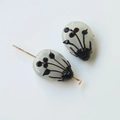 Macro shot of two translucent gray waterdrop glass beads with hand-painted floral patterns - Ink Flower Style / 1 Piece / Milky White