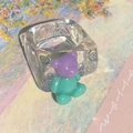 Detail of transparent resin ring featuring a 3D purple and mint green teddy bear charm - Purple & Green