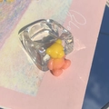 Macro detail of a clear acrylic ring featuring a vibrant 3D gradient resin bear pendant - Yellow Pink