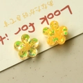 Macro view of yellow resin flower charms with sparkling sequins for DIY jewelry making - Yellow