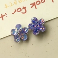 Macro shot of purple resin flower charms with colorful sequins for DIY accessories - Purple