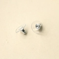 Macro view of silver bullet ear backings with transparent plastic disc support pads - Silver
