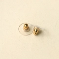 Close-up of golden metal core ear nuts with transparent plastic disc pads for DIY jewelry - Gold