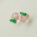 Dettaglio macro di ciondoli pesca rosa traslucidi con foglie verdi per gioielli fai-da-te - Mela Rosa Traslucida