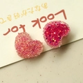 Dettaglio di ciondoli a cuore in resina rosa con finiture opache e glitterate - Rosa Rossa