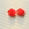 Vue macro de breloques roses en résine rouge montrant les pétales et la base plate pour DIY - Rouge Vif