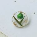 Pendentif rond en résine avec bourgeon vert et feuilles d'or sur carte à bijoux - Patch Simple / Vert
