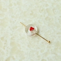 Makro-Detail einer transparenten Glasperle mit rotem Herz auf einem Goldstift - Klein Ca. 0.6 (Eine Kette)