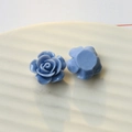Macro view of light blue resin rose flower charms for DIY jewelry and phone case crafts - Haze Blue