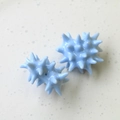 Macro view of light blue star-shaped resin beads for DIY earring and keychain crafts - Blue