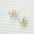 Detail einer handgefertigten Glasperle mit rosa Blumenmuster und goldener Metallschlaufe - Transparente Rosa Blumen-Lampwork-Perle (93#1)