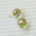 Makro-Detail von handgefertigten Glasperlen mit rosa Blumenmuster und Goldstift - Rosa und Grüne Blumen-Lampwork-Perle (102#10)