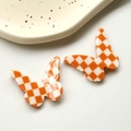 Detail of DIY orange checkered butterfly resin charms for jewelry making - Orange