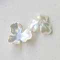 Macro shot of iridescent white three-petal flower beads for DIY jewelry and crafts - Three-Petal Flower
