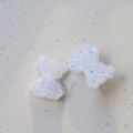 Dettaglio di fiocchi in resina glitterata per creazione di gioielli e accessori DIY - Bianco