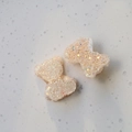 Dettaglio di ciondoli orsetto e fiocco in resina rosa con glitter per accessori fai da te - Beige