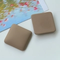 Close-up of matte khaki square resin charms with rounded edges for DIY jewelry making - Brown Square Marble