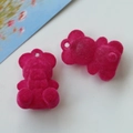 Close-up of rose red flocked mini bear charms for DIY jewelry and accessory making - Rose Red