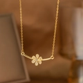 Macro view of gold flower pendant necklace with laurel leaf detail and zircon stones - Bar Flower Style (9163)