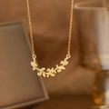 Close-up of golden laurel leaf pendant with sparkling white cubic zirconia on a delicate chain - Branch Vine Wrapped Style (9179)