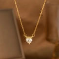 Macro close-up of a golden heart-shaped zircon pendant on a delicate chain necklace - Three-Prong Heart Single Diamond (9183)