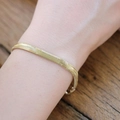 Detail eines 18K vergoldeten Schlangenketten-Armbands aus Edelstahl auf Holzoberfläche - 6mm Weiche Schlangenkette Armband