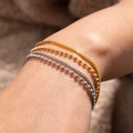 Detailansicht der 18K vergoldeten und silbernen Perlen- und Box-Gliederketten am Handgelenk - Gold Box Chain Layered